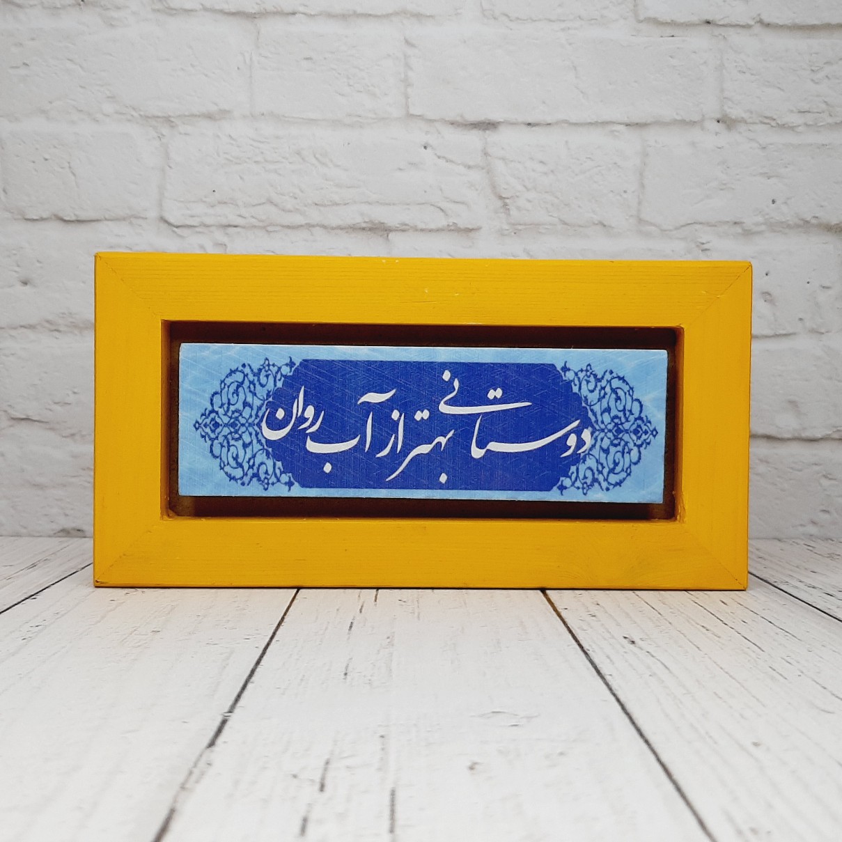 تابلو شعرنوشته روی سنگ با قاب زرد دوستانی بهتر از آب روان